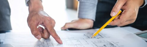 Construction engineering or architect discuss a blueprint while checking information on drawing and sketching, meeting for architectural project of partner.